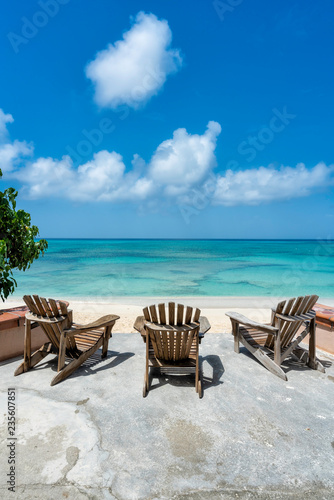 Wooden beach chairs in front of tropical ocean