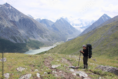 Man with a backpack standing on the pass Kara-Turek, view of the Akkem Lake, Altai Mountains, Russia