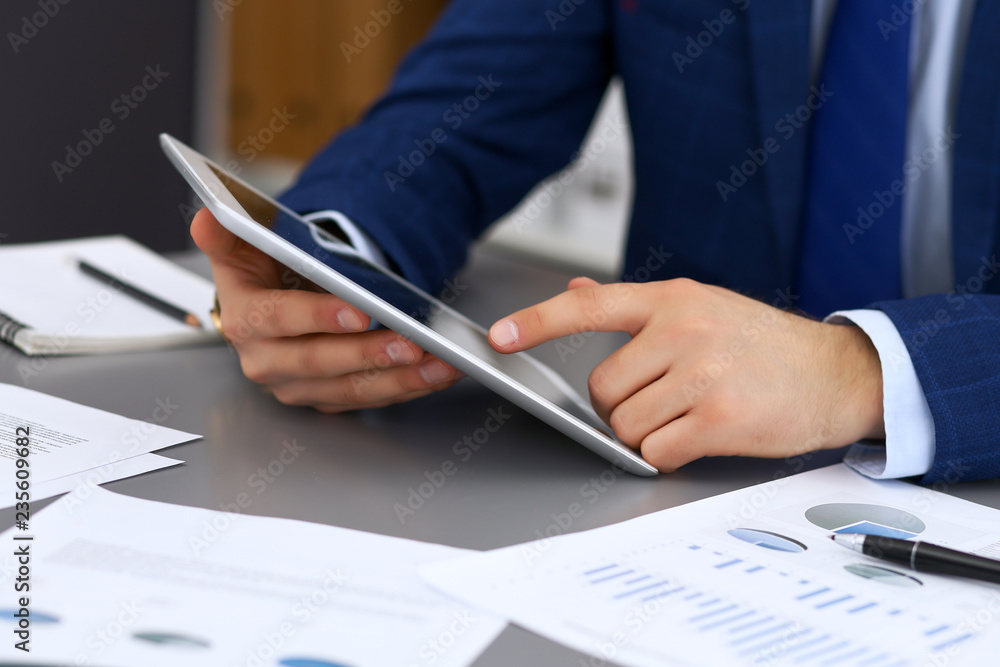 Businessman using touchpad at meeting, closeup of hands Businessman using touchpad at meeting, closeup of hands