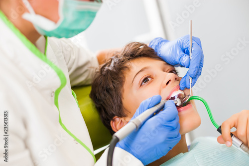 Dentist is repairing teeth of a little boy. 