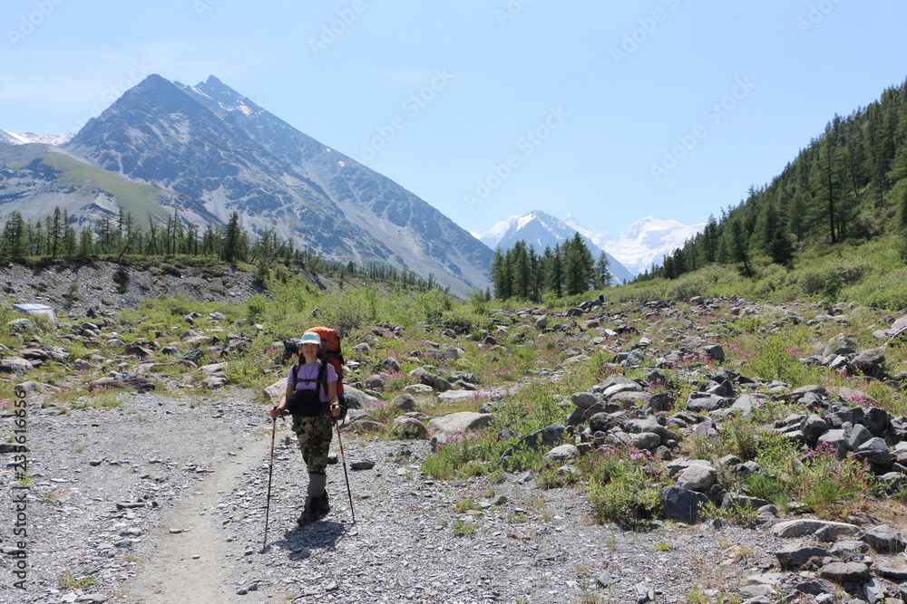 Tourist woman standing at the foot of the Belukha Mountain, Altai, Russia