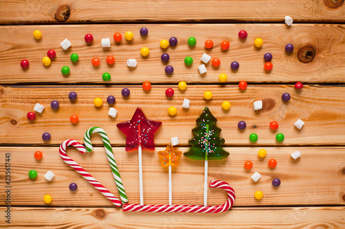Christmas colorful lollipops on the wooden background. Space for a text. Top view.
