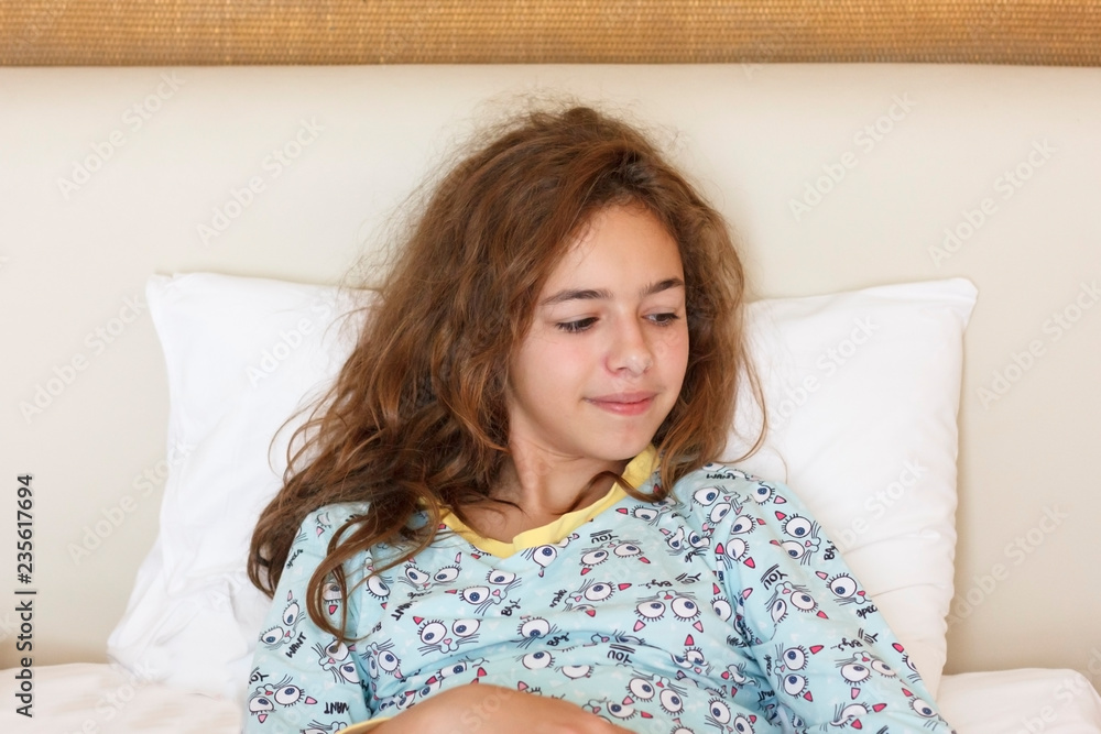 Just awake pretty teenager girl with funny emotion face and wild hair on the bed Just awake pretty teenager girl with funny emotion face and wild hair on the bed