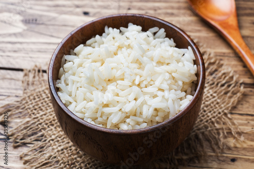 White boiled rice in a wooden bowl. Rustic style. photo