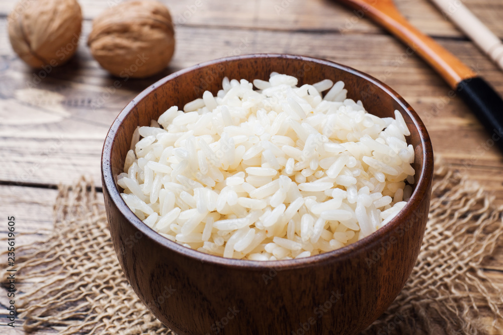 White boiled rice in a wooden bowl. Rustic style. White boiled rice in a wooden bowl. Rustic style.