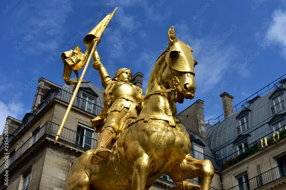 Paris, France. Jeanne d’Arc golden statue. Blue sky with white clouds.
