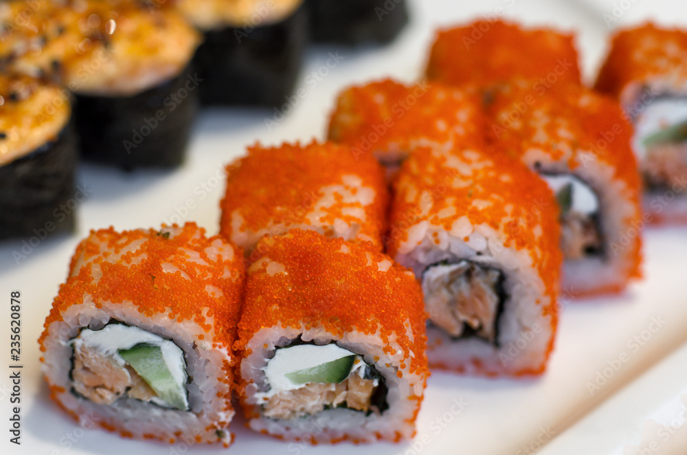 Orange sushi rolls California with caviar in a row close-up Orange sushi rolls California with caviar in a row close-up