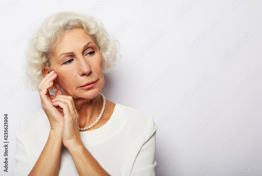 Thoughtful serious senior woman feeling blue worried about problems, pensive upset sad middle aged grey haired lady looking away thinking of loneliness Thoughtful serious senior woman feeling blue worried about problems, pensive upset sad middle aged grey haired lady looking away thinking of loneliness