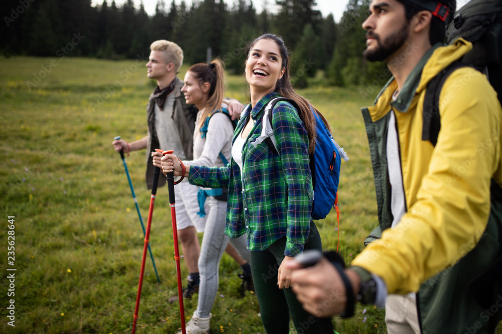 Group of hikers walking on a mountain and smiling Group of hikers walking on a mountain and smiling
