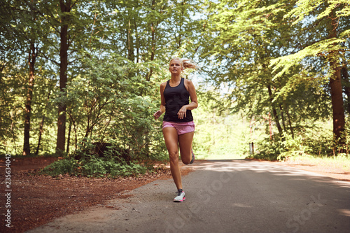 Young woman jogging alone along a path in the forest