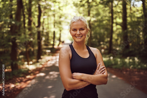 Sporty young woman smiling before a forest run