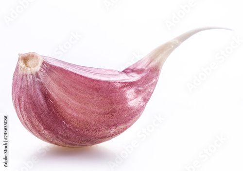 Unpeeled garlic clove on white background.
