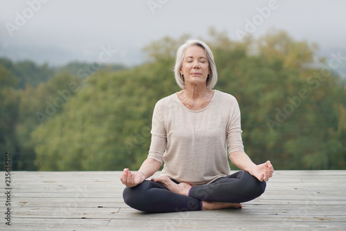   Serene senior woman meditating outdoors