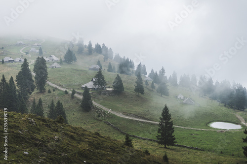 Nice view of Velika Planina - The Geat Pasture - Slovenia. Misty mountains, shepherd houses, green rolling hills. photo