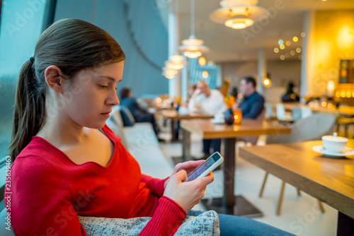 Frau wartet auf Verabredung und liest Nachrichten auf dem Smartphone