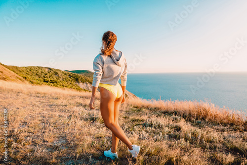 Happy attractive woman in nature at warm sunset. Holidays in the mountains