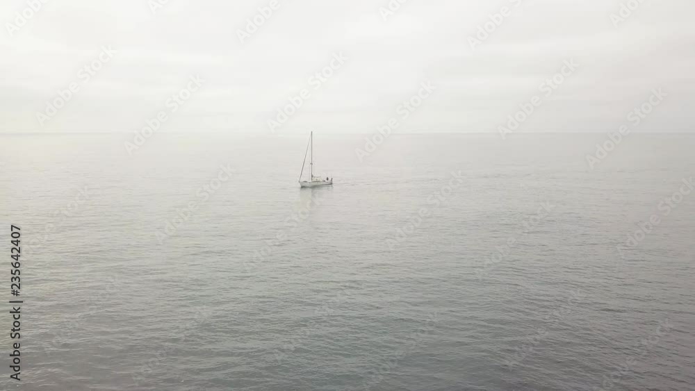 Sail boat sailing in blue sea and cloudy sky landscape on horizon. Aerial view Sail boat sailing in blue sea and cloudy sky landscape on horizon. Aerial view