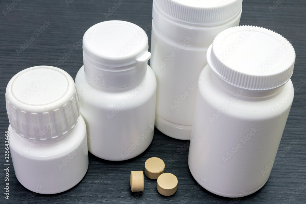 white boats of pills of different sizes, conceptual image white boats of pills of different sizes, conceptual image