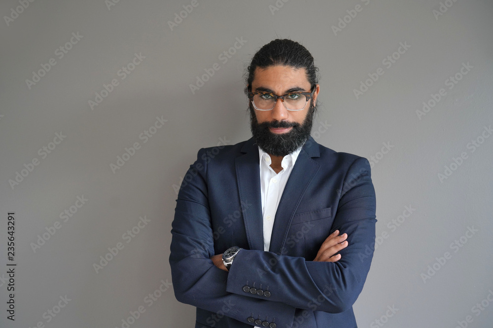 Hipster style businessman standing on grey background Hipster style businessman standing on grey background