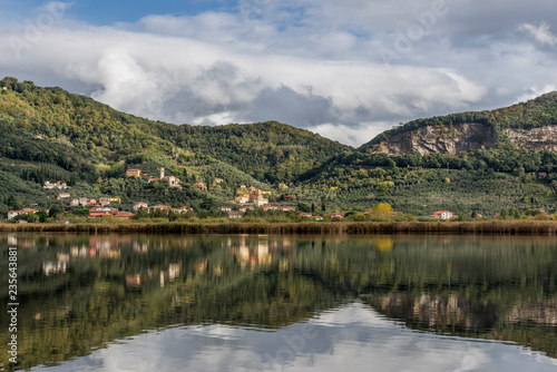 The characteristic village of Massaciuccoli is reflected in the waters of the homonymous lake, Lucca, Tuscany, Italy