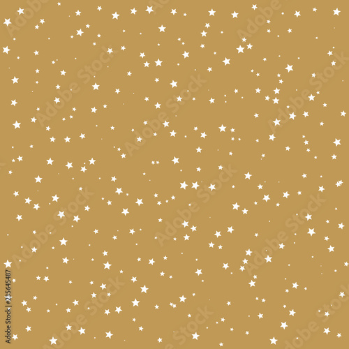 White star texture in random size and pattern on a golden background. Randomly scattered star symbols on a decorative gold paper.