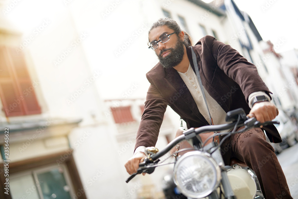 Hipster guy riding electric vintage bicycle
