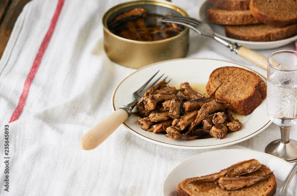 Canned sprats with oil and bread on a plate Canned sprats with oil and bread on a plate