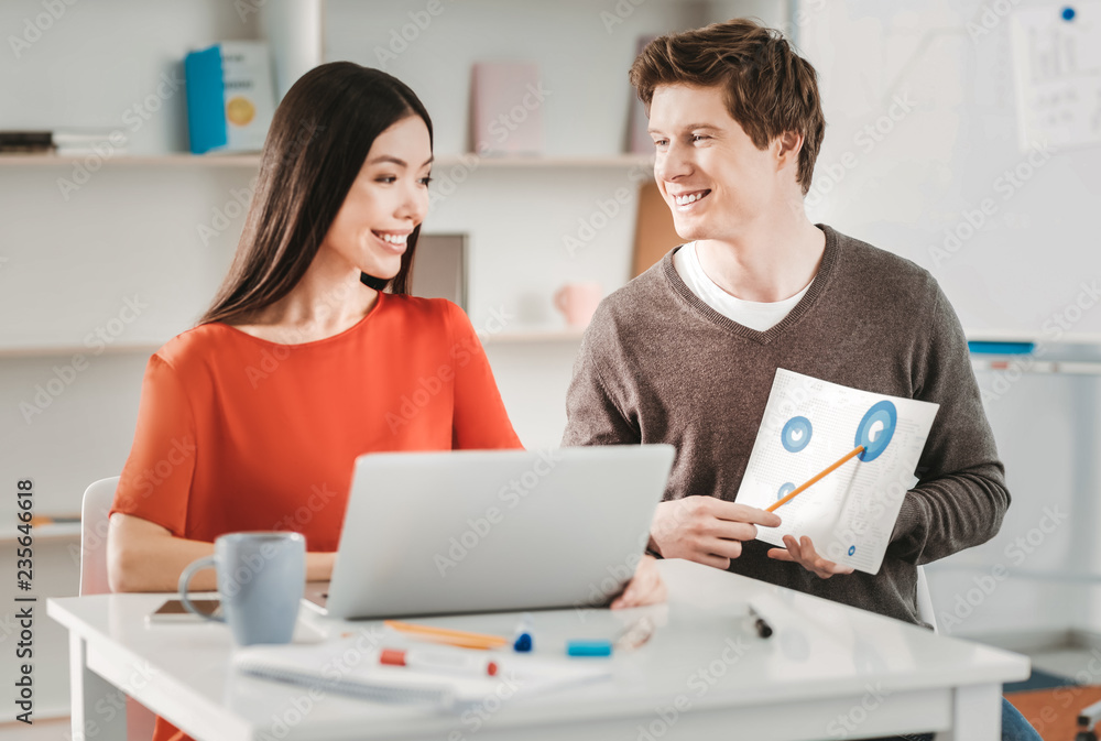 Smiling man joining her girlfriend during work Smiling man joining her girlfriend during work