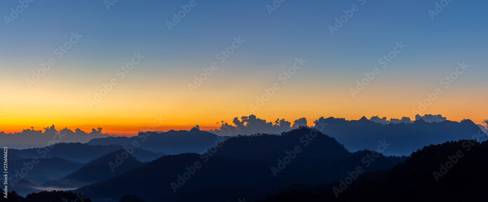 Fototapeta premium Sunrise with early morning sky and mountain scene covered in fog