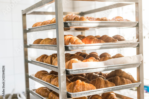 rack full of fresh tasty croissants in bakehouse