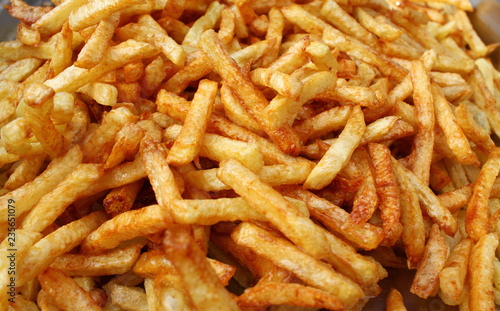 Tasty french fries full frame photo. Fat oiled French fries. Diet killing fried potatoes. Pile of fried potatoes. Potato chips background patter. French fries wallpaper. USA fast food concept.