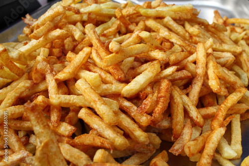 Tasty french fries full frame photo. Fat oiled French fries. Diet killing fried potatoes. Pile of fried potatoes. Potato chips background patter. French fries wallpaper. USA fast food concept.