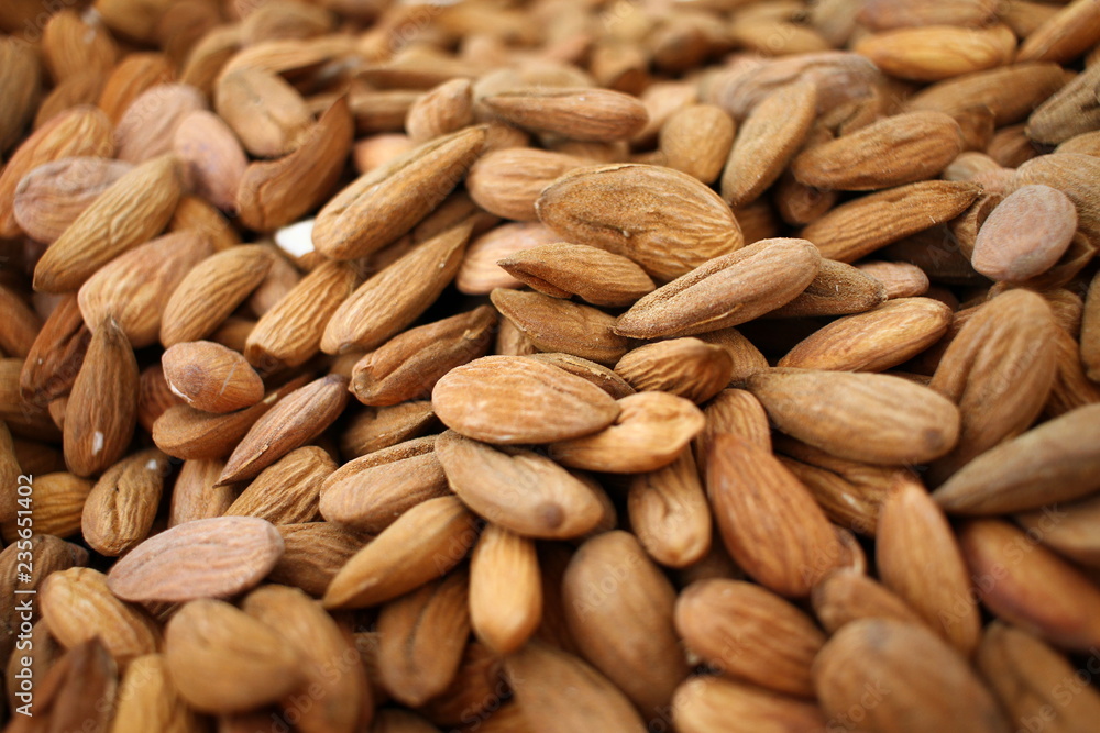 Almonds. Background of big raw peeled almonds situated arbitrarily. Nuts wallpaper pattern. Clipping path. Peeled almonds close up. For vegetarians. Nut pattern. Almonds. Background of big raw peeled almonds situated arbitrarily. Nuts wallpaper pattern. Clipping path. Peeled almonds close up. For vegetarians. Nut pattern.
