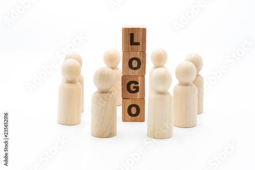 Wooden figures as business team in circle around word LOGO