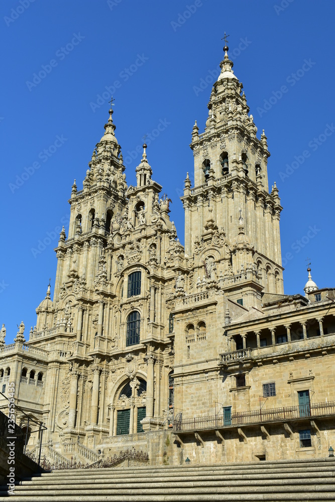 Cathedral, side view from stone stairs. Obradoiro facade and towers with blue sky, Santiago de Compostela, Spain.
