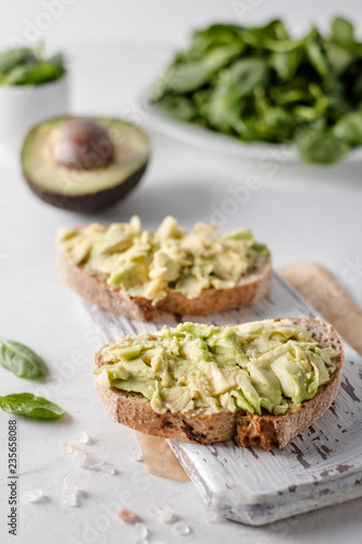 Delicious wholewheat toast with avocado slices. Close up fresh soft avocado toasts.