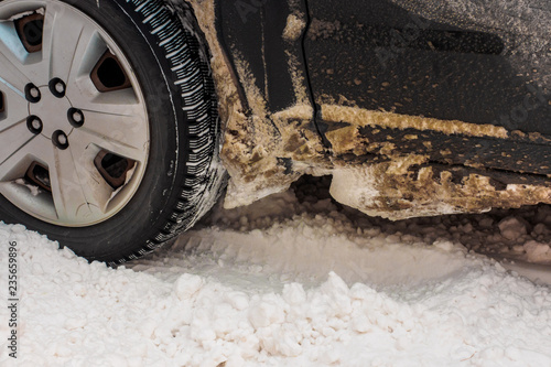 Car tires on winter road covered with snow. Vehicle on snowy alley in the morning at snowfall © Evgeniy