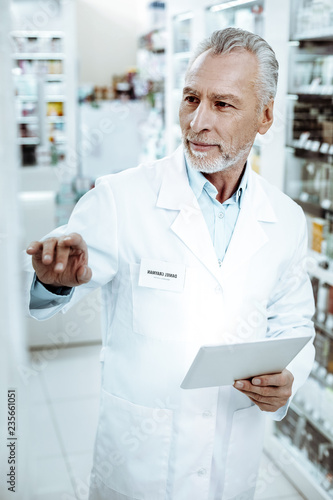 Attentive male person checking the amount of medicine