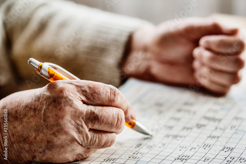 Seniorin löst ein Kreuzworträtsel im Seniorenheim photo