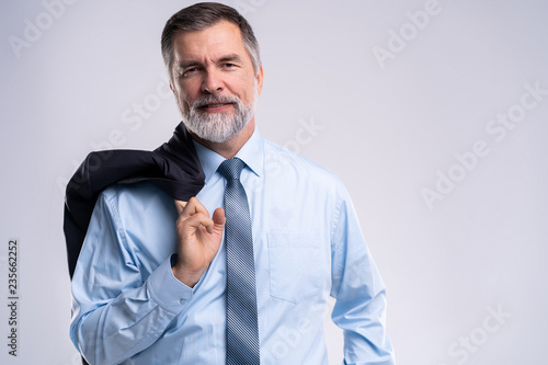 Happy satisfied mature businessman looking at camera isolated on white background. © opolja