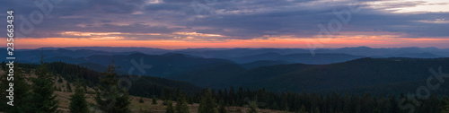 Majestic pink and purple sunrise in the morning in the mountains. Amazing sunrise over Carpathian mountains in the summer. Panoramic morning scene.