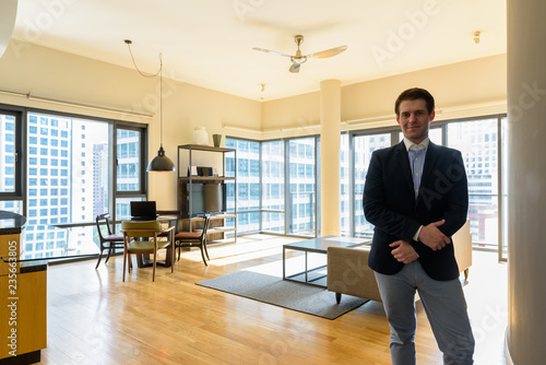 Wallpaper Mural Young handsome businessman relaxing in the living room Torontodigital.ca