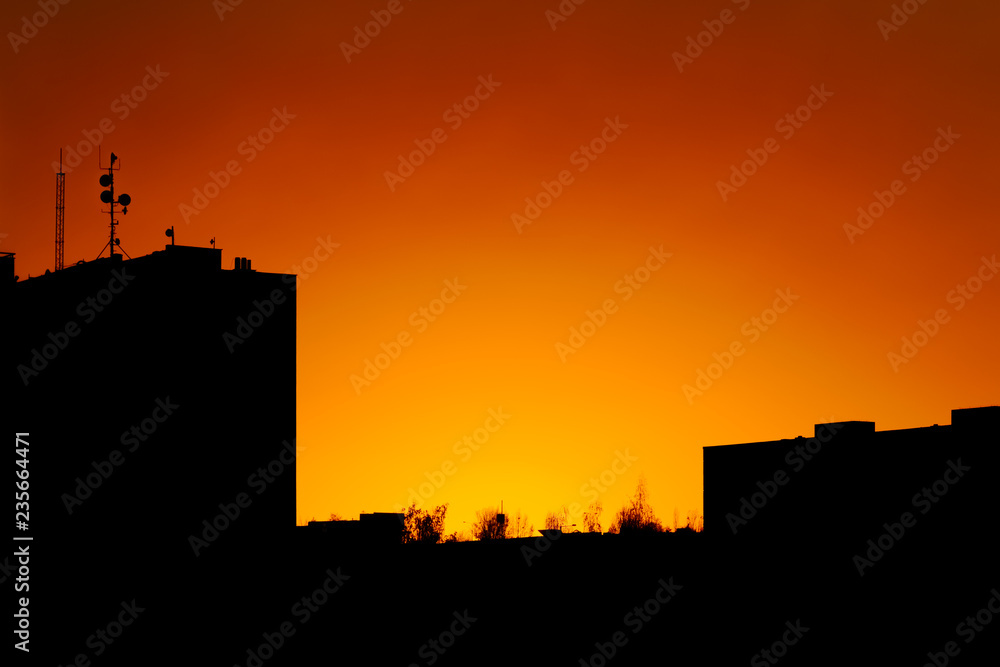 Urban landscape silhouette in a dramatic sunset with yellow and red sky