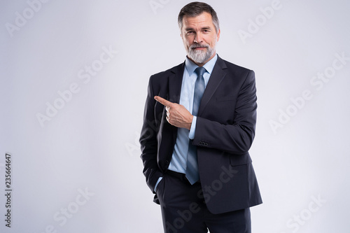 Portrait Of Happy Mature Businessman Presenting Isolated On White Background. photo