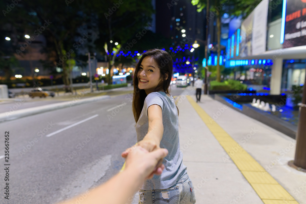 Young beautiful Asian woman holding hand of man Young beautiful Asian woman holding hand of man