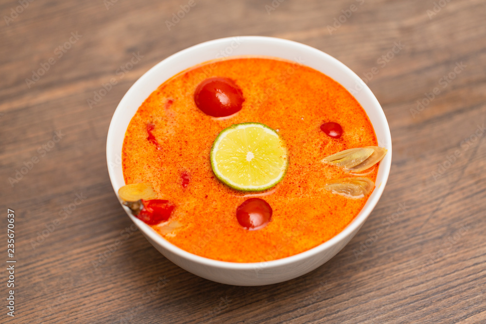 Tom Yum Kung-Thai spicy shrimp soup in white bowl on wooden table Tom Yum Kung-Thai spicy shrimp soup in white bowl on wooden table