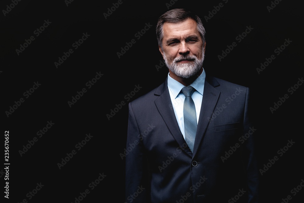 Handsome mature business man isolated on black background Handsome mature business man isolated on black background