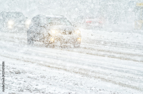 Car rides through a snowstorm. Limited vision on the road. Blizzard - car traffic in bad weather conditions photo