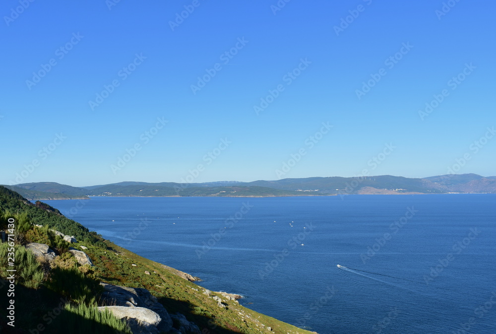 Cliff in Finisterre (“The End of the World”) close to the lighthouse. Galicia, Spain. Blue sea, sunny day.
