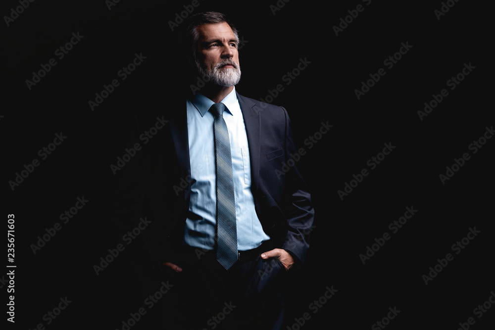 Handsome mature business man isolated on black background Handsome mature business man isolated on black background